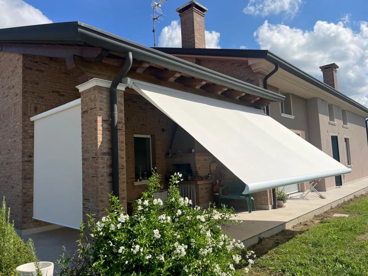 Tenda da sole bianca aperta su un portico